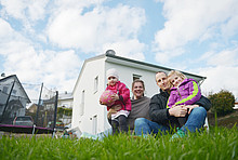 Familie vor dem sanierten Eigenheim.